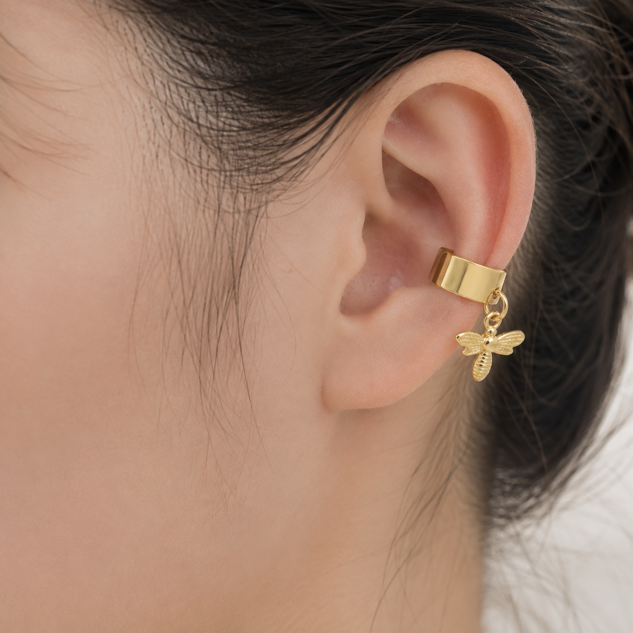 Ear cuff abeille pendante porté sur le cartilage de l'oreille