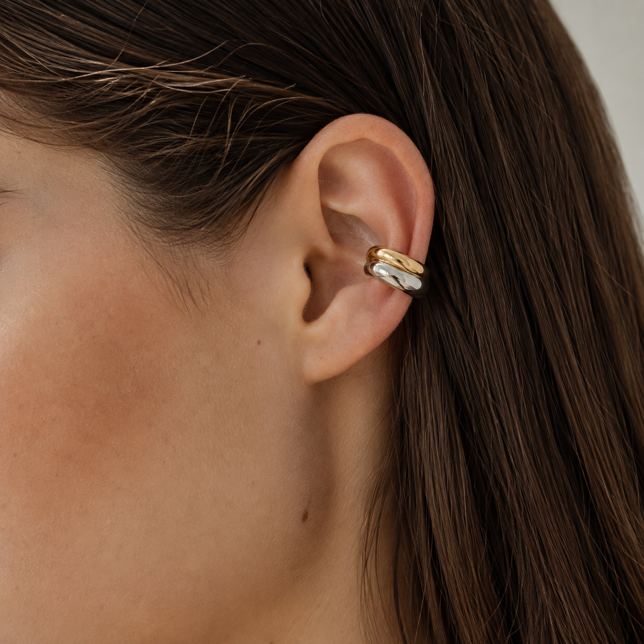 Ear cuff bicolore entrelacé porté sur le cartilage de l'oreille