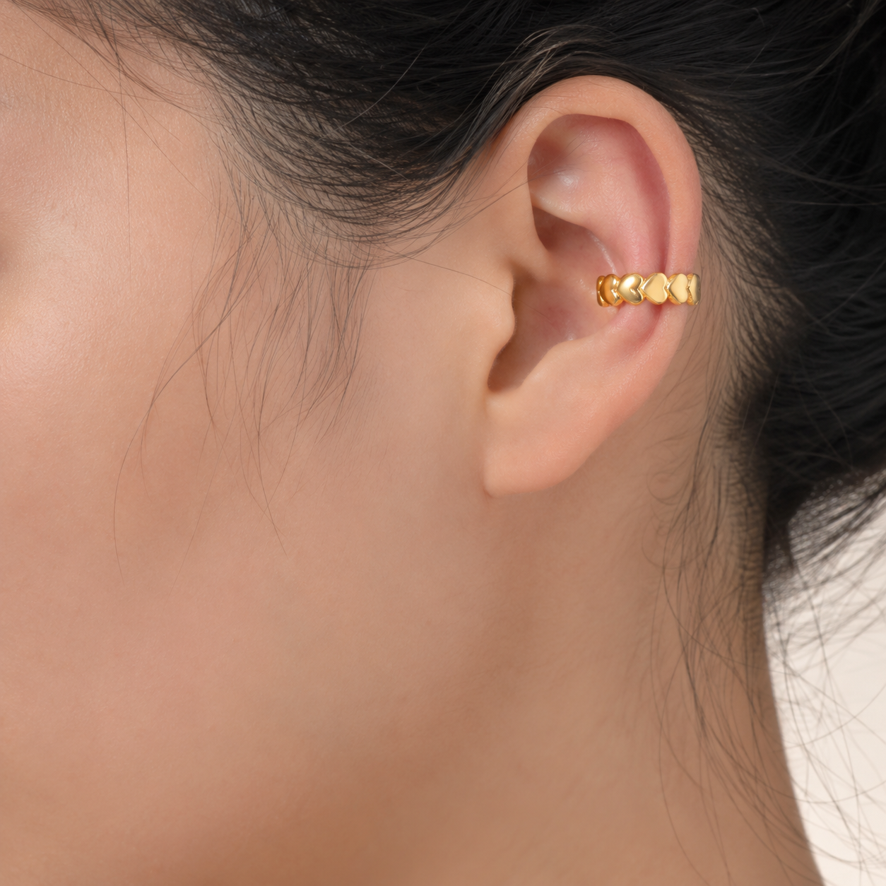 Ear cuff cœurs alignés porté sur le cartilage de l'oreille
