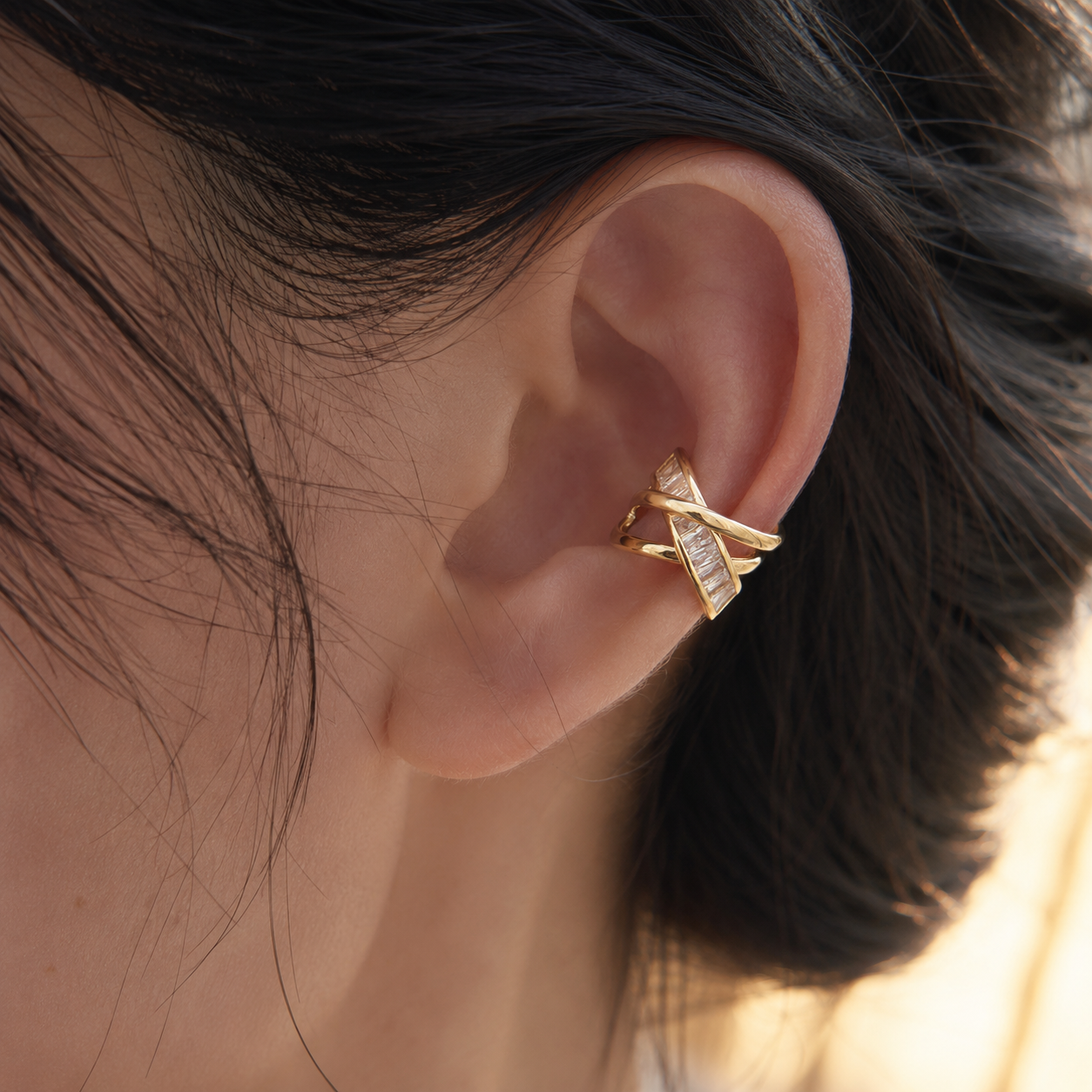 Ear cuff croisé pavé baguette porté sur le cartilage de l'oreille