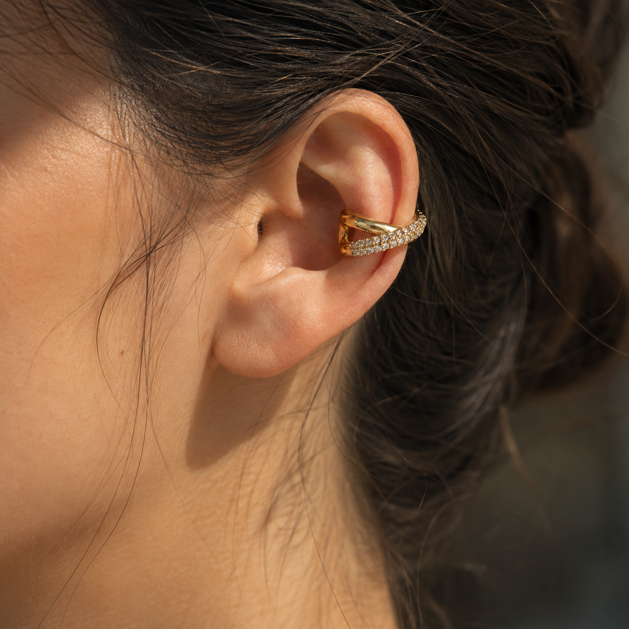 Ear cuff croisé pavé porté sur le cartilage de l'oreille
