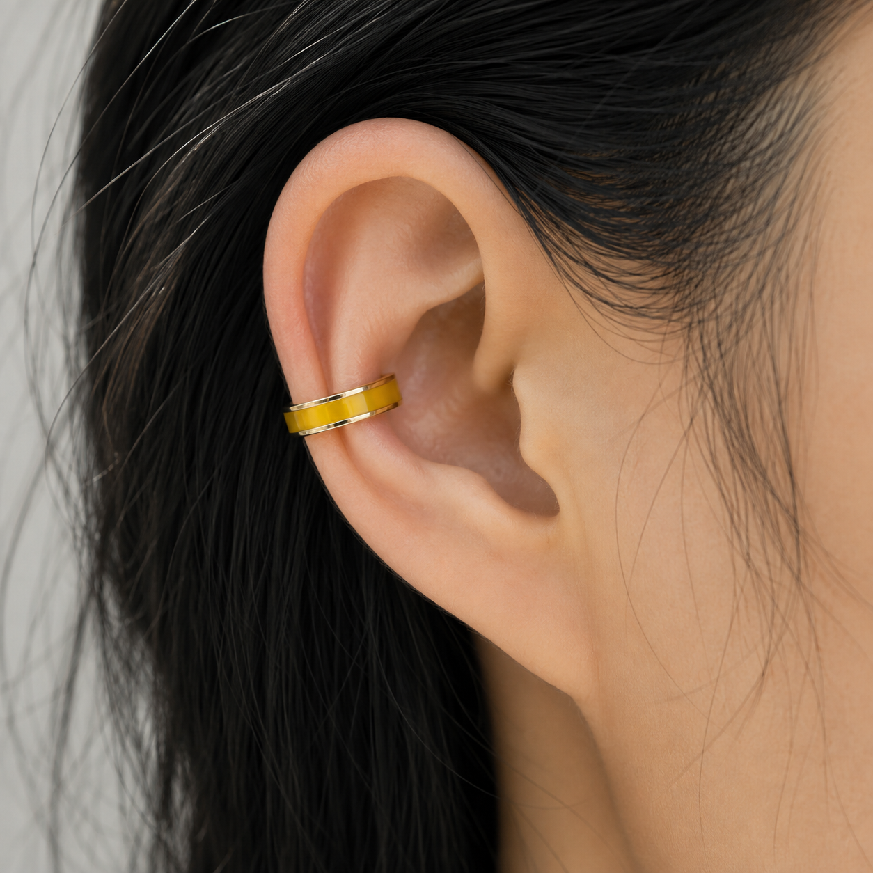 Ear cuff émaillé coloré porté sur le cartilage de l'oreille