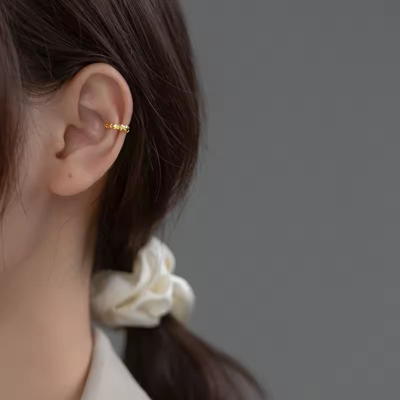 Ear cuff étoilé porté sur le cartilage de l'oreille
