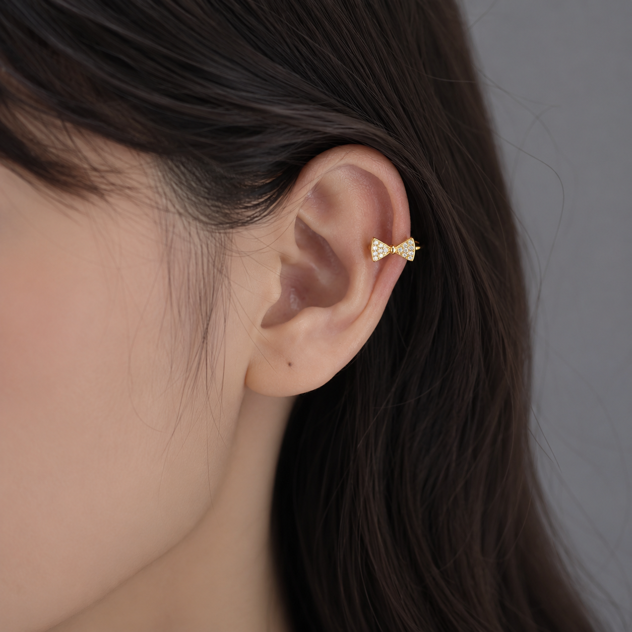 Ear cuff nœud brillant porté sur le cartilage de l'oreille