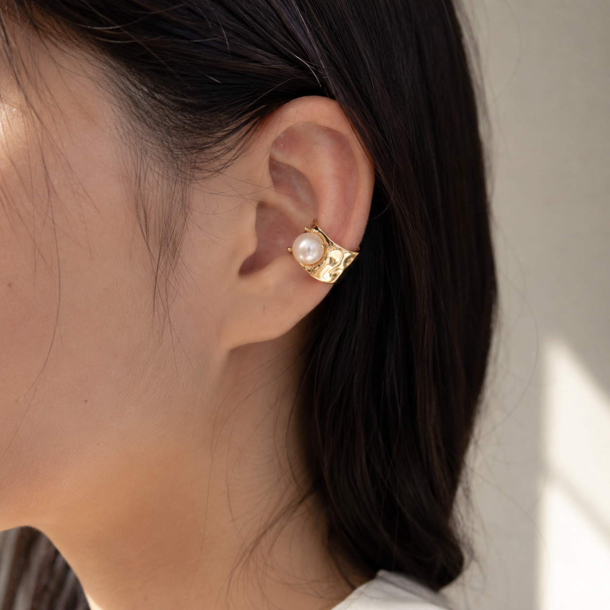 Ear cuff perle carrée porté sur le cartilage de l'oreille