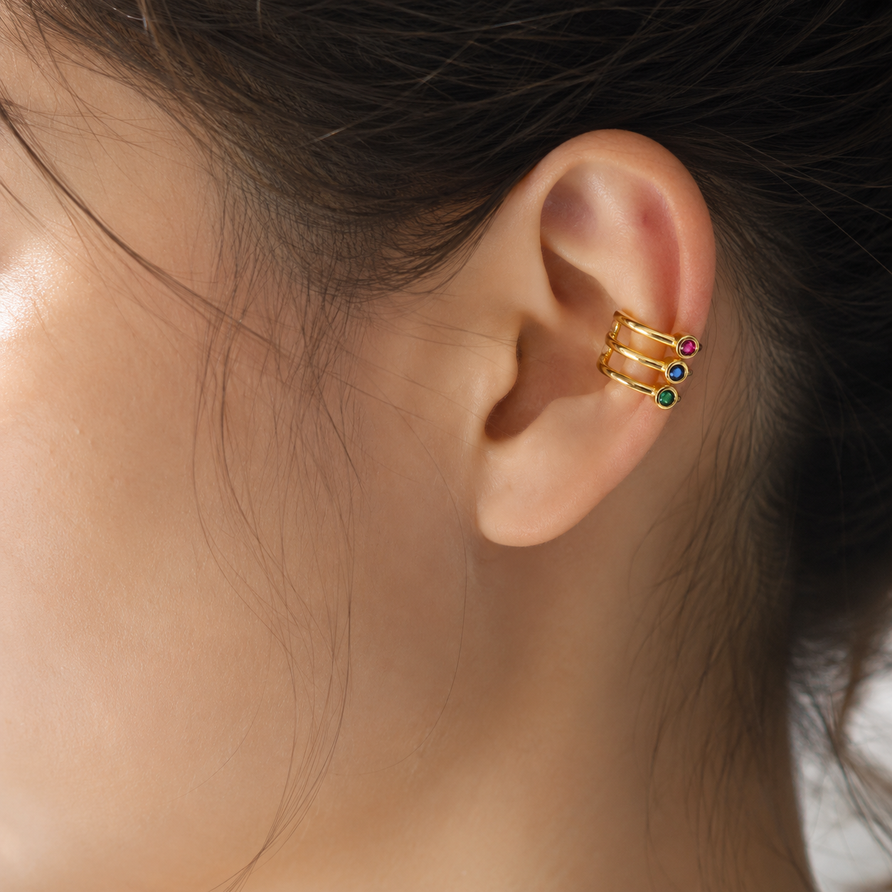 Ear cuff triple ligne solitaire porté sur le cartilage de l'oreille