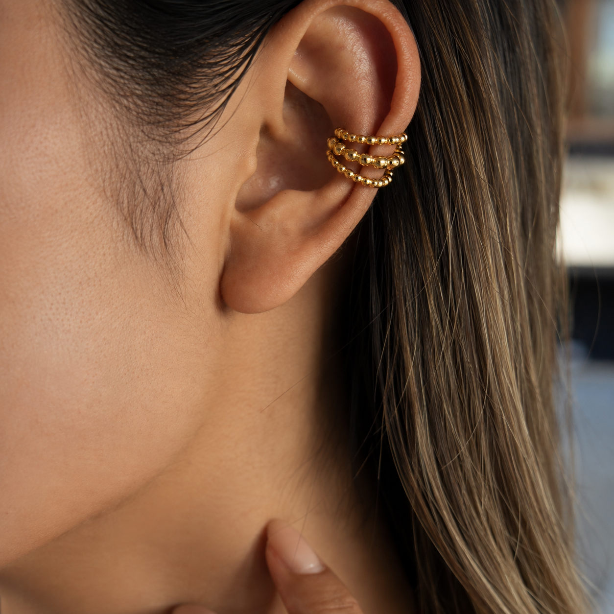 Ear cuff triple perlé porté sur le cartilage de l'oreille